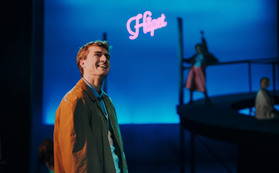 Fra «HIM igjen» i Festiviteten. Neonskiltet «Håpet» lyser over scenen.